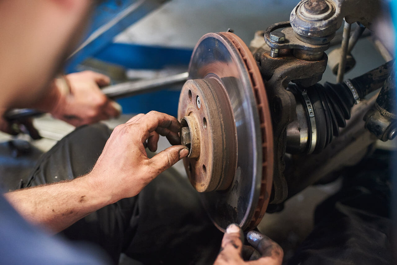 A skilled mechanic at Motorfix is meticulously repairing a car's brake disc, ensuring every vehicle receives top-quality brake service.