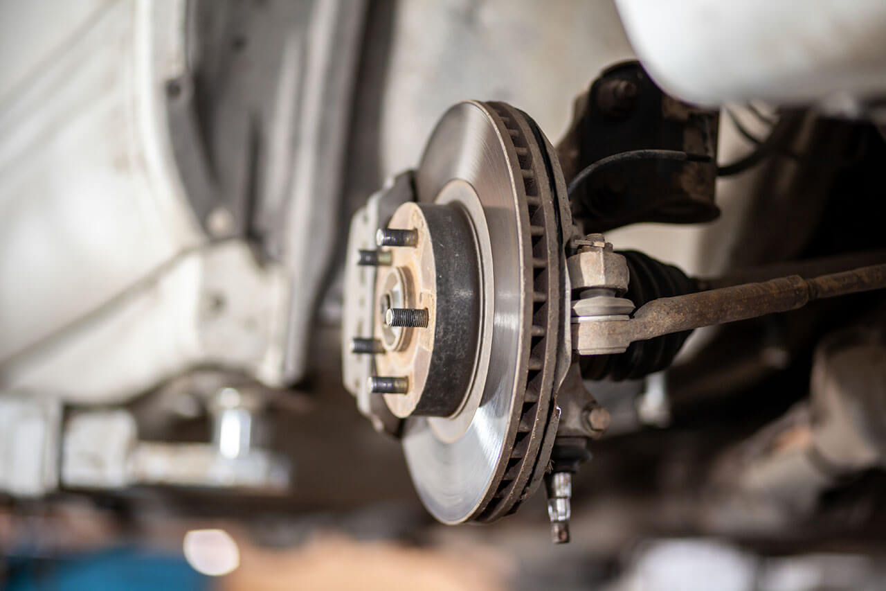 Close-up view of a vehicle's disc brake assembly during a repair at Motorfix, highlighting their attention to detail in brake servicing.